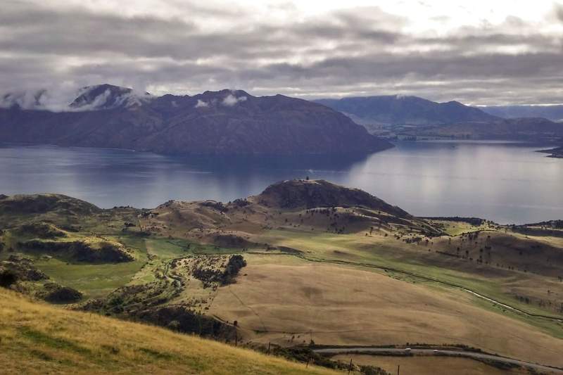 Schist cliffs and tussock hills above Lake Wānaka, a rock climbing area in Otago