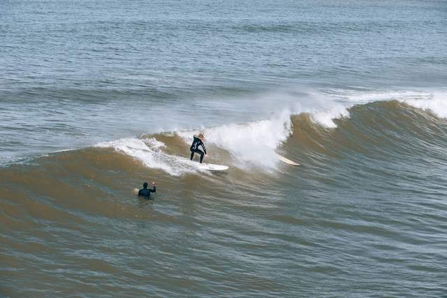 A surfer riding a clean green wave